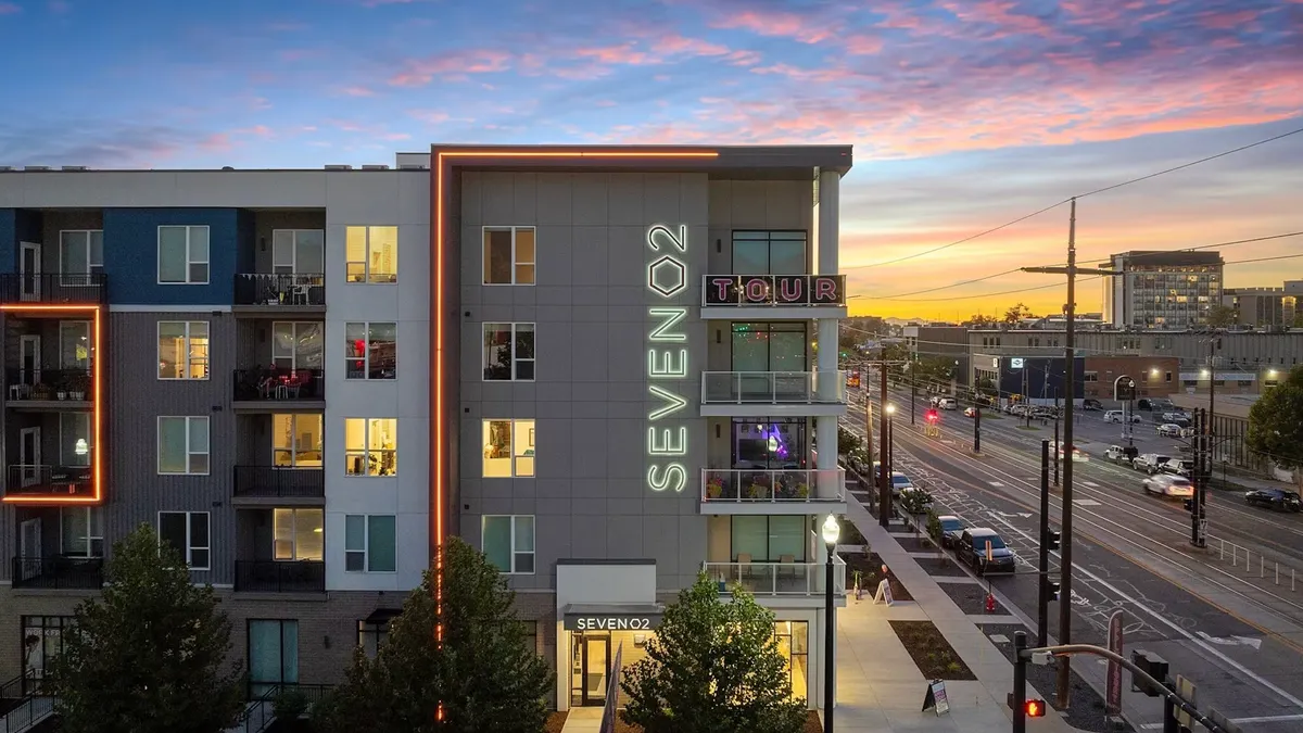Four-story modern apartments with streets on either side.