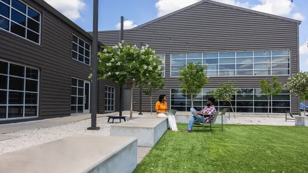 Two employees in an outdoor atrium.
