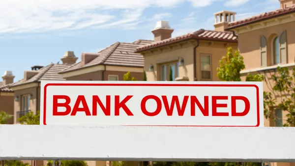 bank owned sign with homes in the background