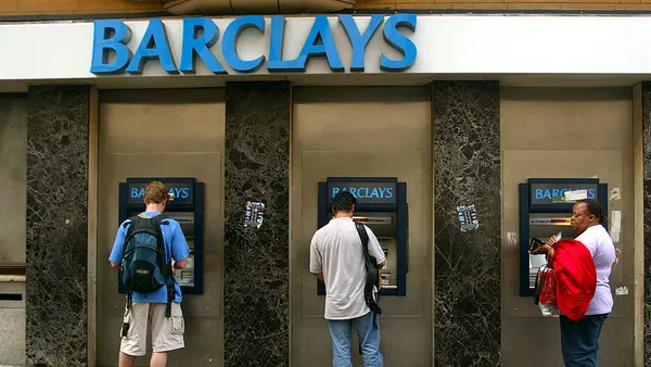 People seen using an ATMs at a Barclays bank.