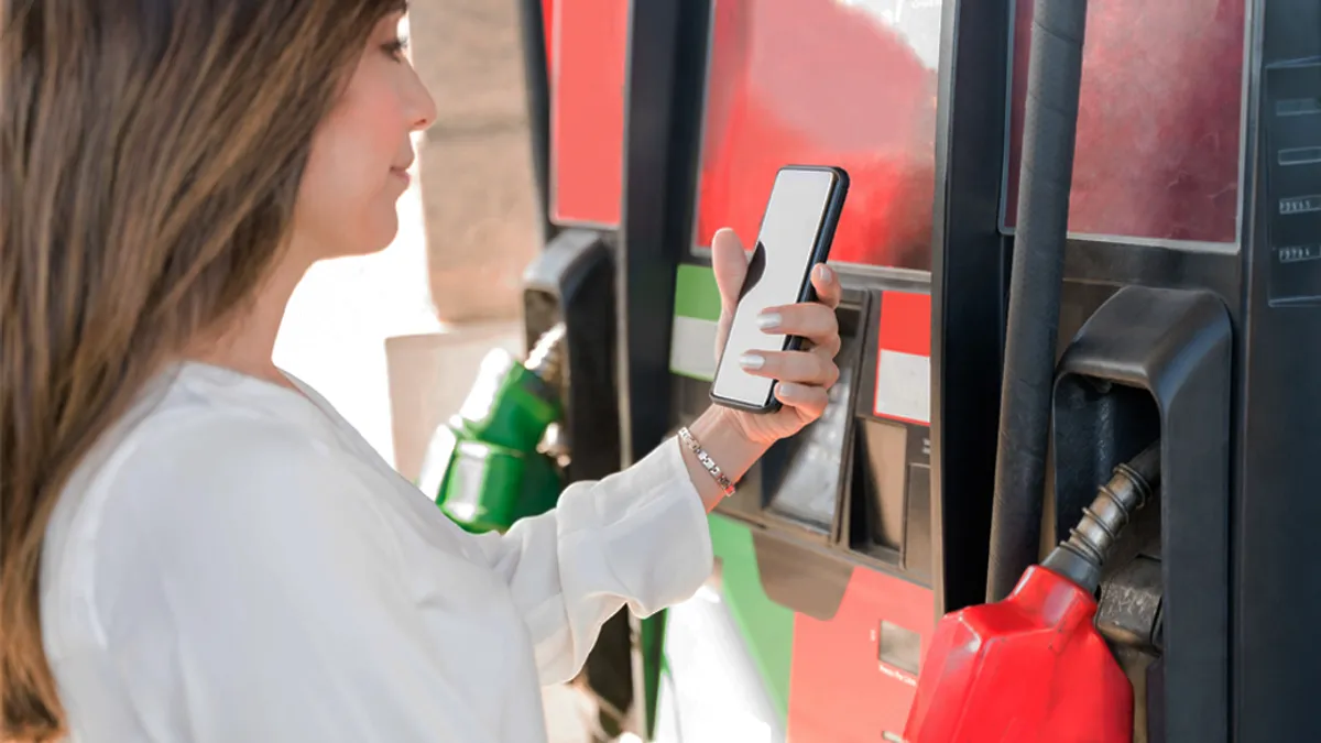 Woman in gas station checking phone