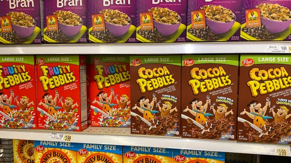 Cereal is lined in a row, reading "Raisin Bran, Fruity Pebbles, Cocoa Pebbles, and Honey Bunches of Oats."