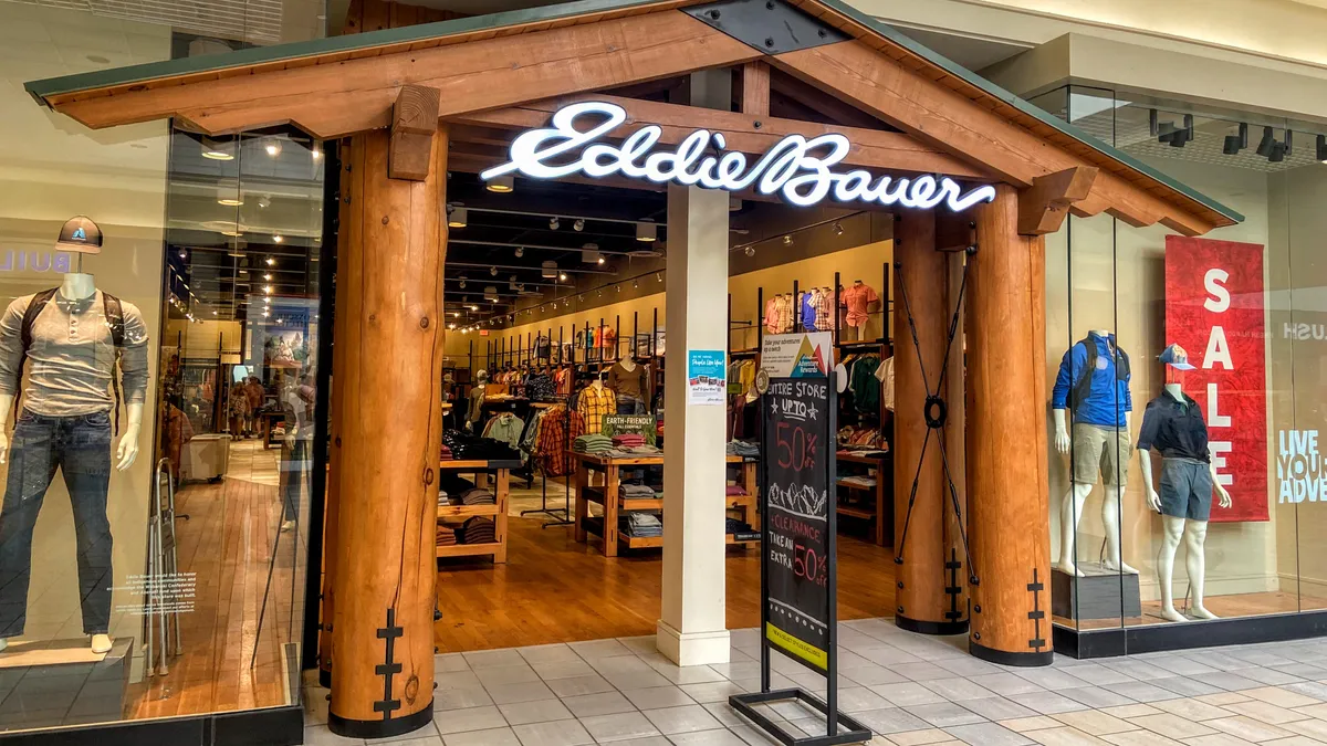 An Eddie Bauer mall store entrance mimics a log cabin, with faux wooden pillars and pitched roof.