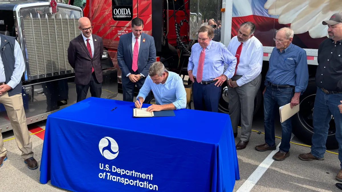 U.S. Department of Transportation Secretary Sean P. Duffy signs an order announcing new English-language proficiency enforcement guidelines at a May 20 event in Austin, Texas.