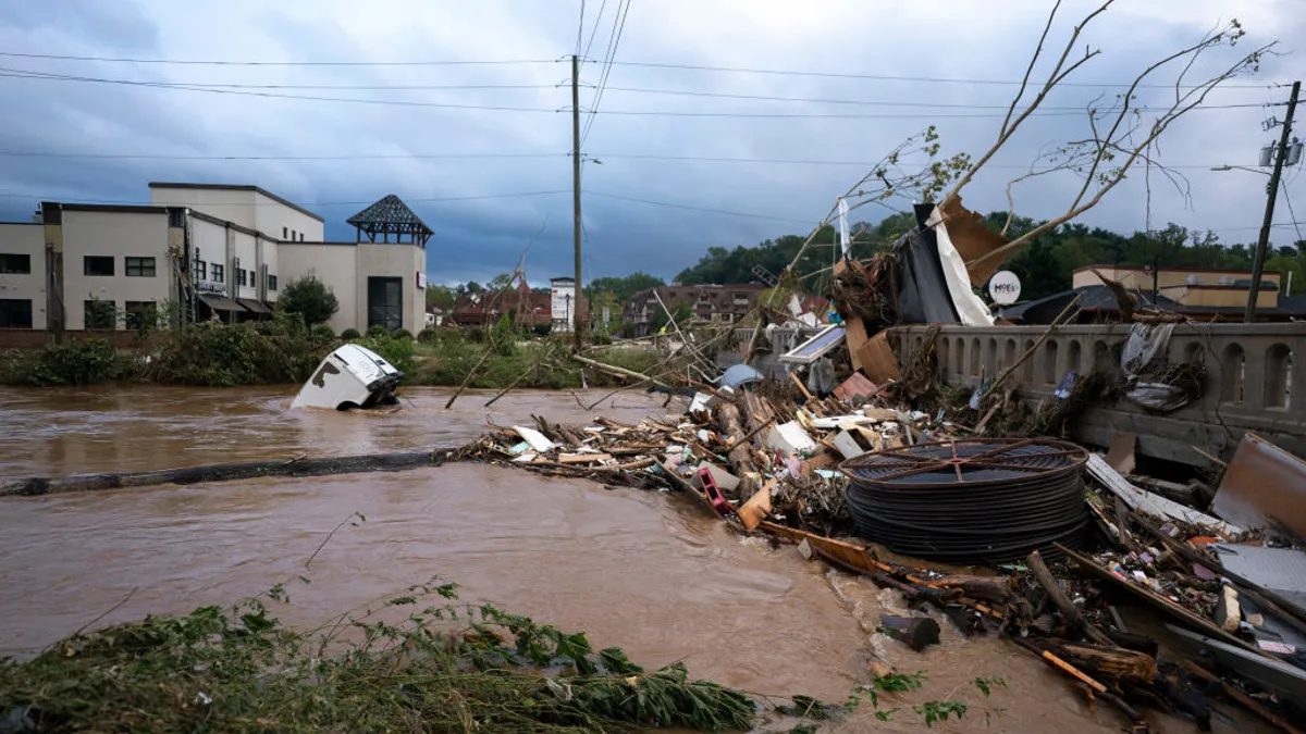 A van flows in floodwaters near the Biltmore Village in the aftermath of Hurricane Helene on September 28, 2024 in Asheville, North Carolina. Hurricane Helene made landfall Thursday night in Florida's Big Bend with winds up to 140 mph.