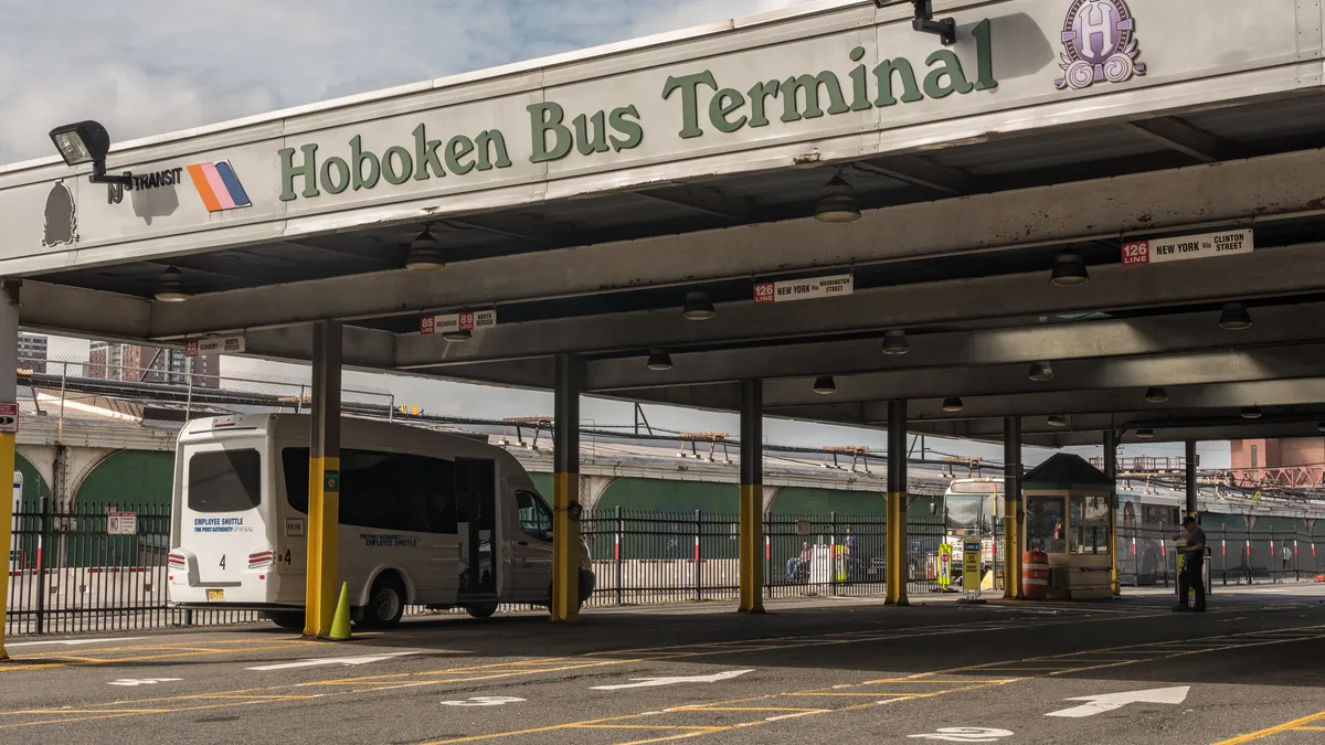 Open-air structure lettered "Hoboken Bus Terminal" with one van parked on the side.