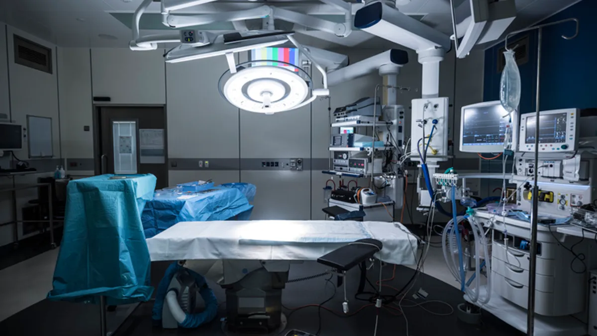 An empty hospital operating theater is prepared with lighting and equipment