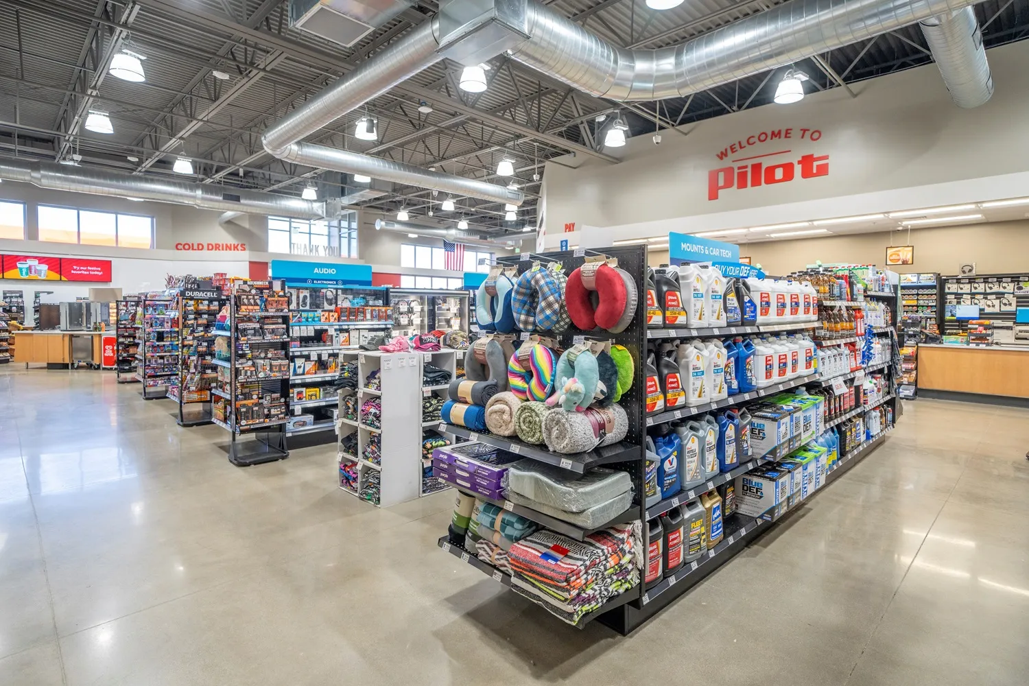 A photo of the inside of a store, showing merchandise like car maintenance items and cold weather gear. A sign on the wall says &quot;Welcome to Pilot.&quot;