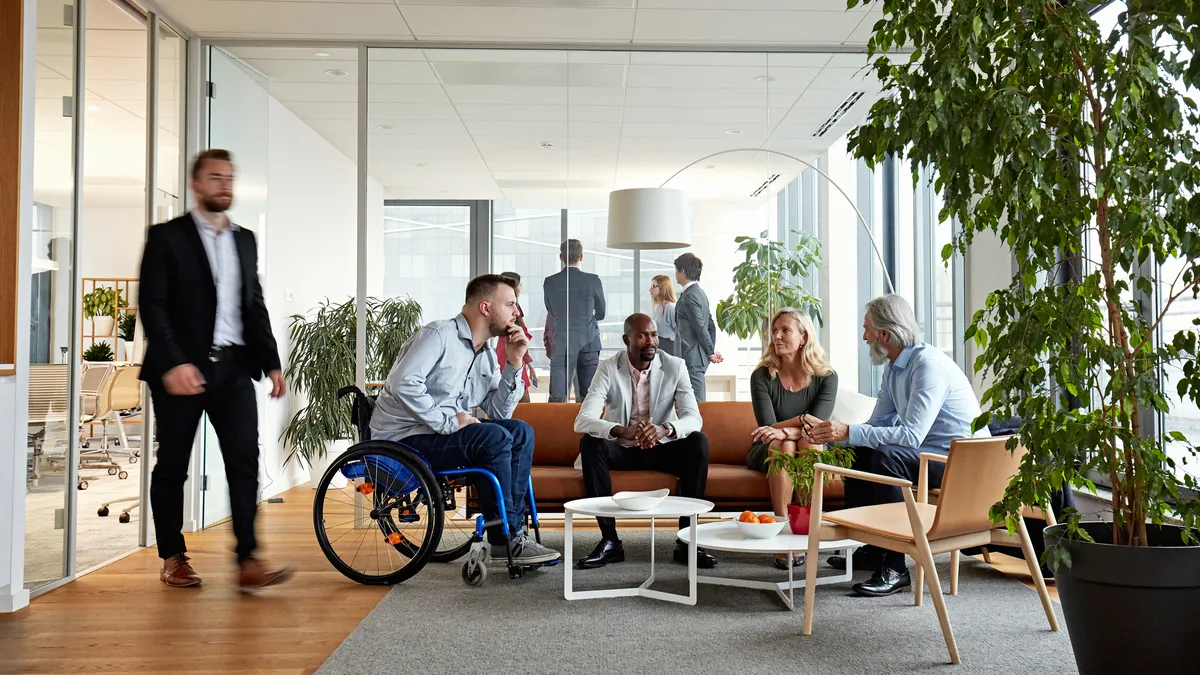 Group of four people meeting in an office common area