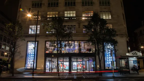 A large, lit-up sportswear store at night.