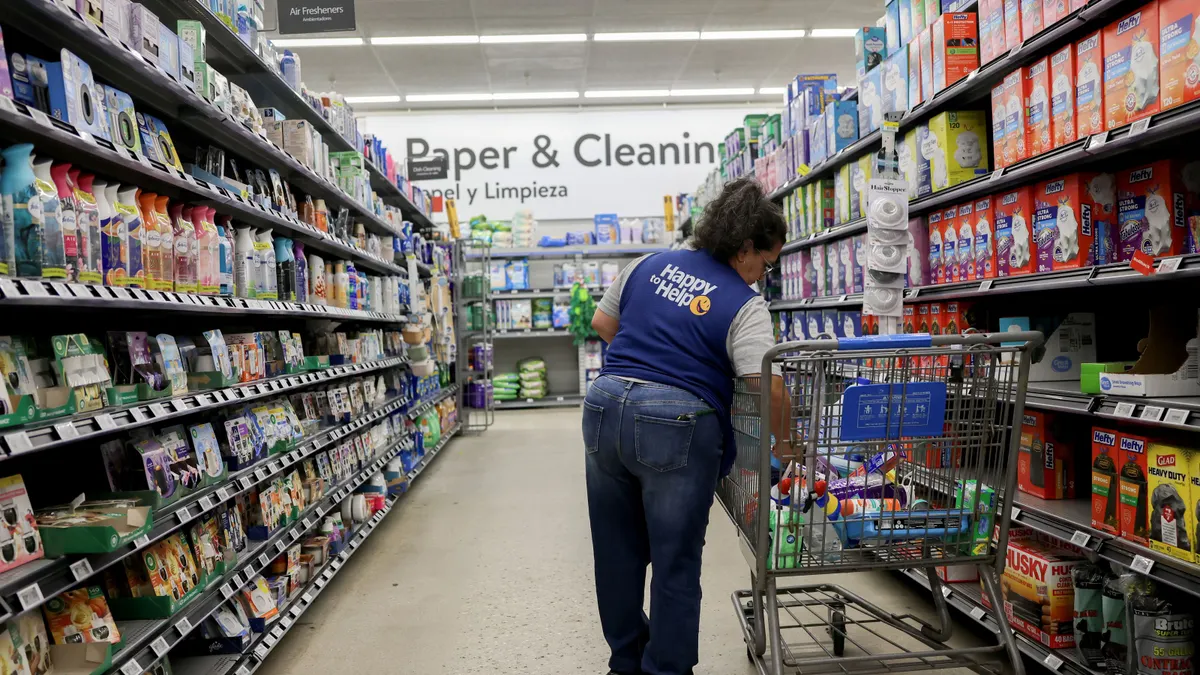 A person stocks shelves inside a Walmart retail store.