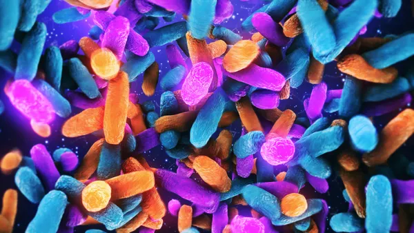 A collage of pnk, blue and orange bacteria-like blobs float around against a dark blue background.