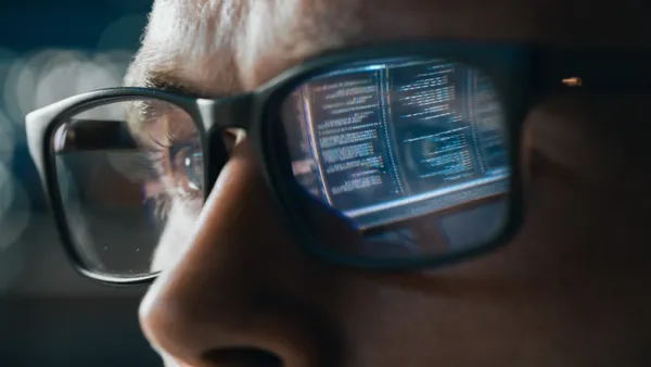 Close-up Portrait of Software Engineer Working on Computer, Line of Code Reflecting in Glasses.