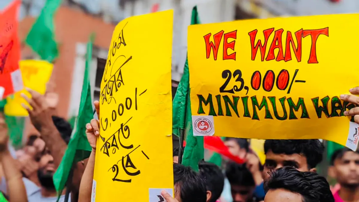 Garment workers in Bangladesh protest for a higher minimum wage by holding signs and raising flags.