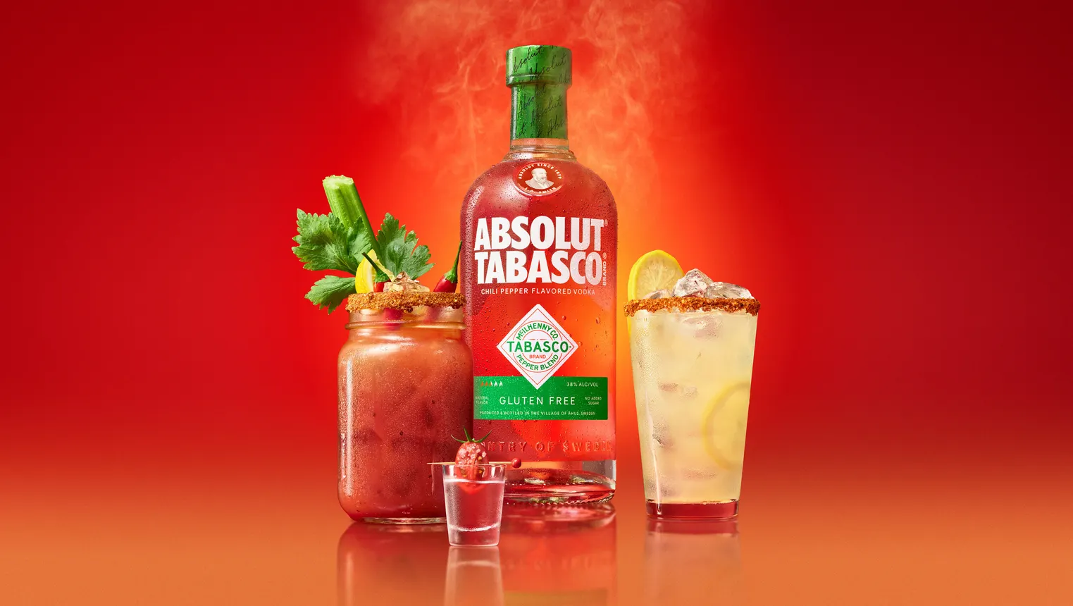 A bloody mary, shot glass and spicy lemonade are displayed next to a bottle of Absolut and Tabasco.