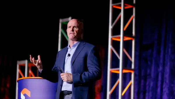 A man speaks on stage. The word NWN is visible.