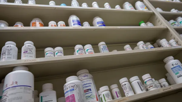 Bottles of medications sit on shelves at a pharmacy.