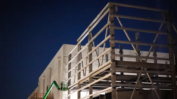 A white data center under construction is seen under a night sky with stars.