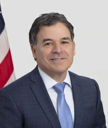 Headshot of Frank Yiannas with United States flag in the background
