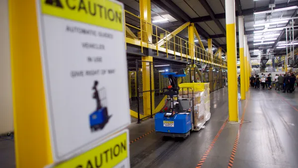 A robotic machine moves through a warehouse.