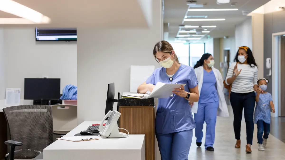 A doctor walks a patient to their room.