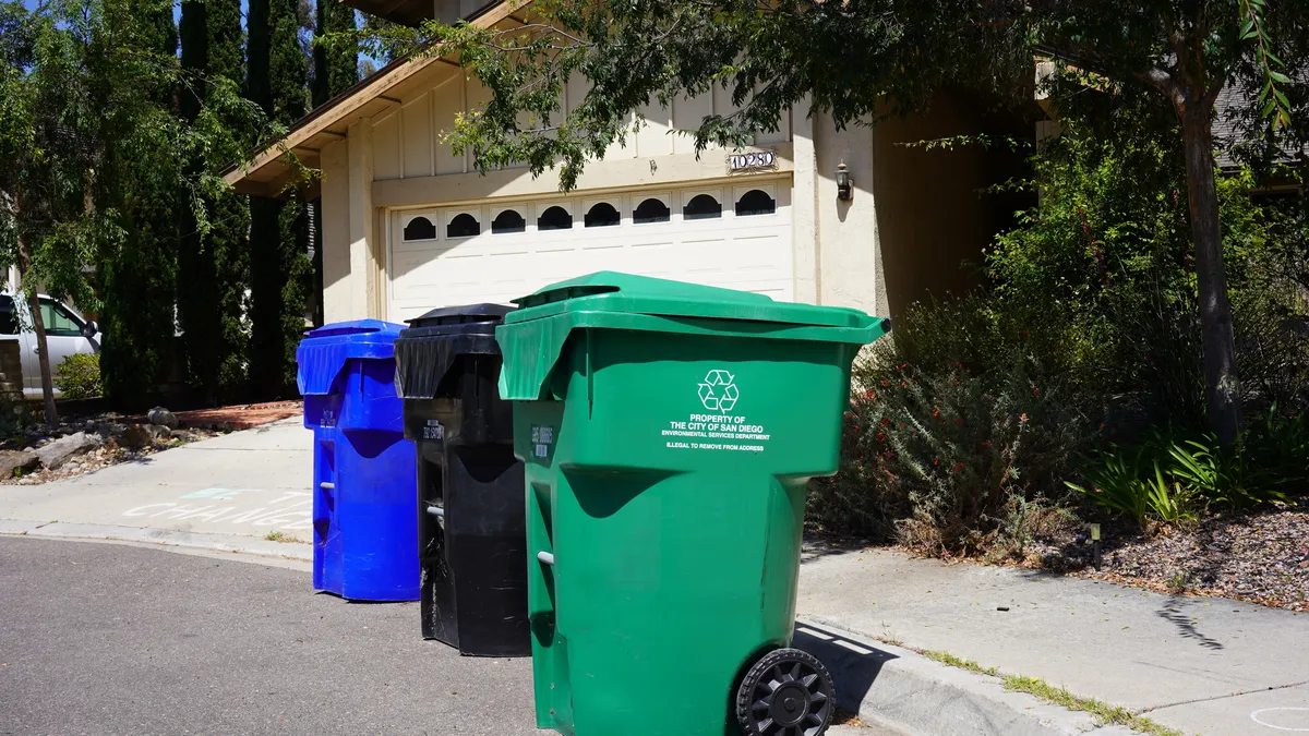 Three carts on curb in San Diego - blue for recycling, black for trash and green for organic waste