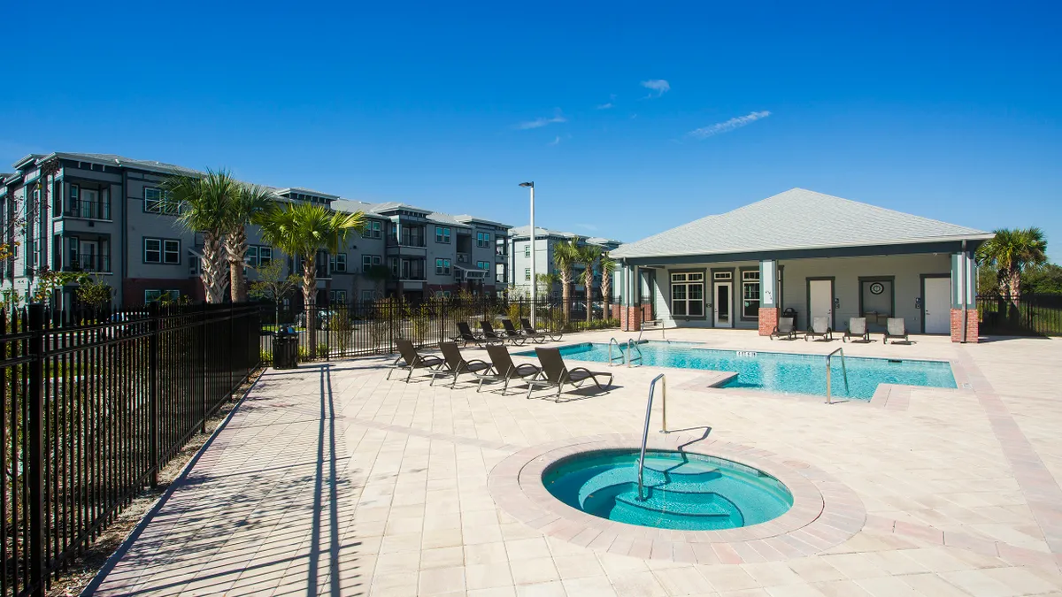 Apartment building with pool in the foreground.