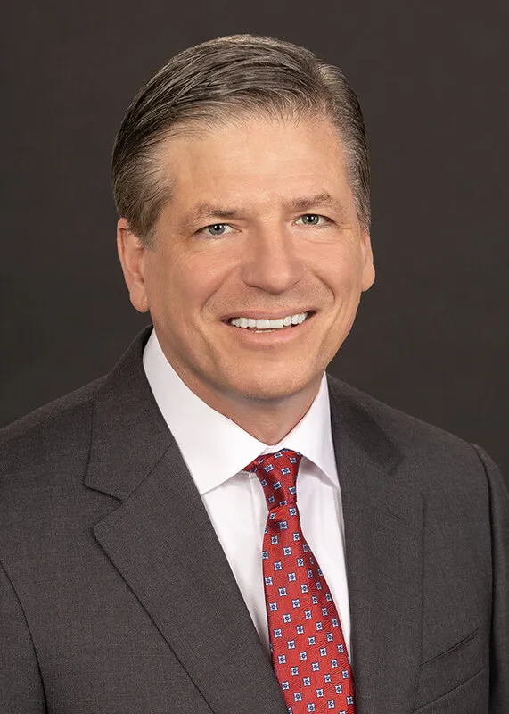 A headshot of Tom Hamic, International Paper&#x27;s executive vice president and president of North American Packaging Solutions, wearing a gray blazer and red tie