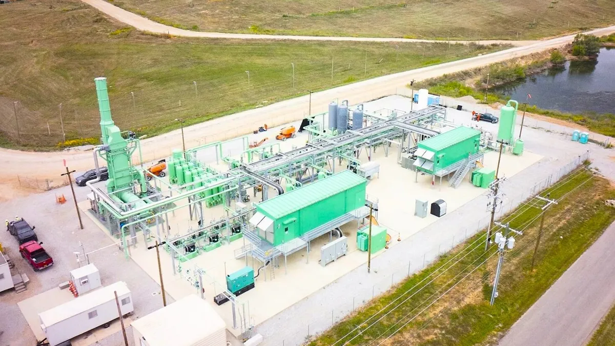 An industrial facility on a concrete pad near a landfill.