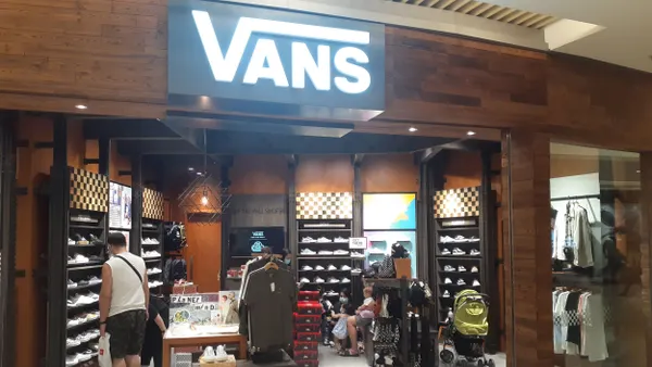 A Vans store in a mall. A shopper is inside.