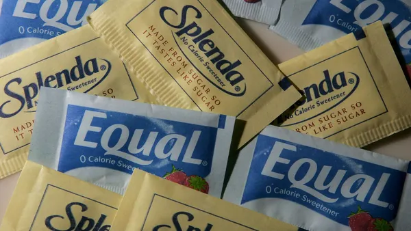 Packages of Equal and Splenda artificial sweeteners are displayed at a coffee shop