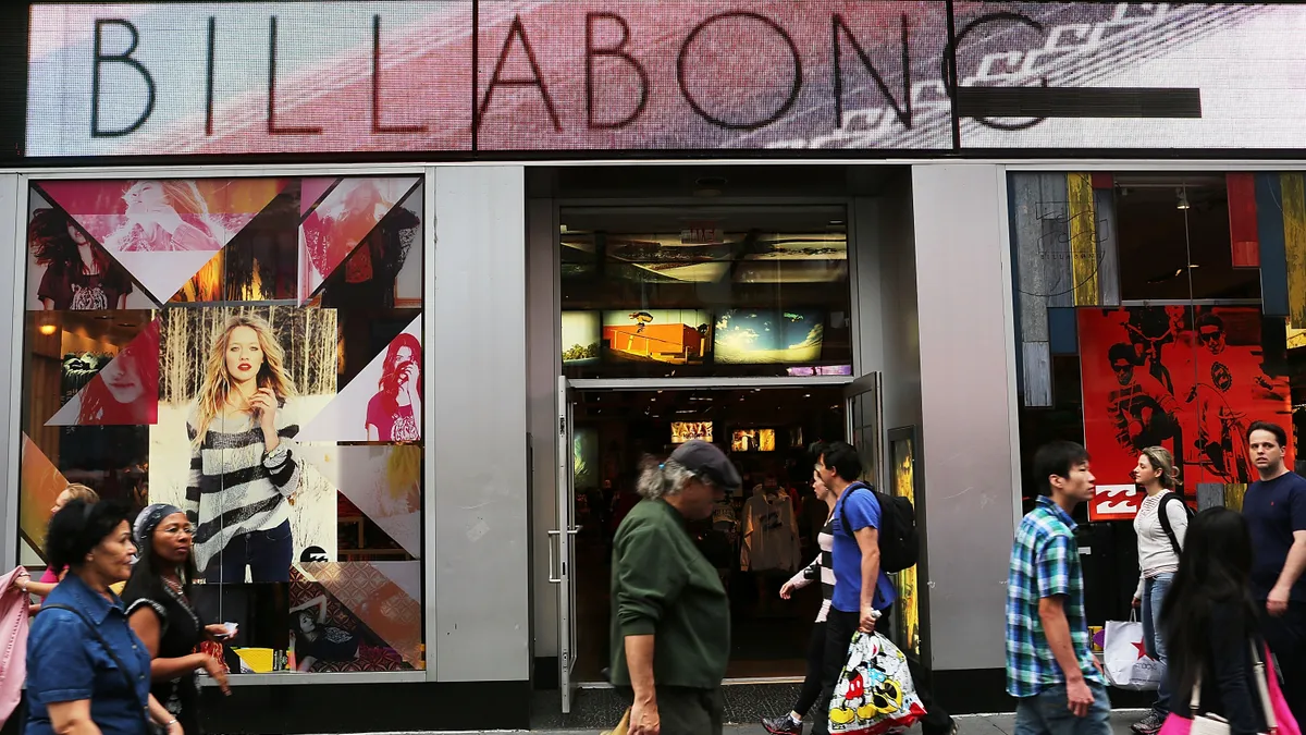 A billabong storefront is pictured as people walk past it.