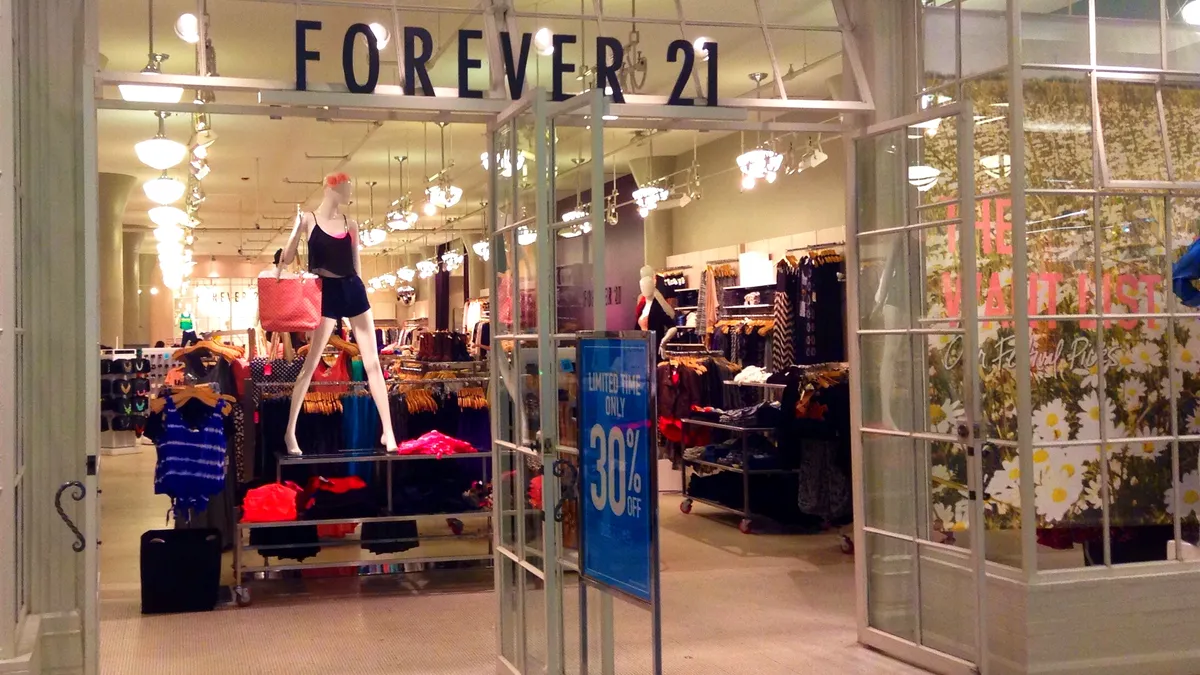 The mall entrance of a brightly light "Forever 21" store.