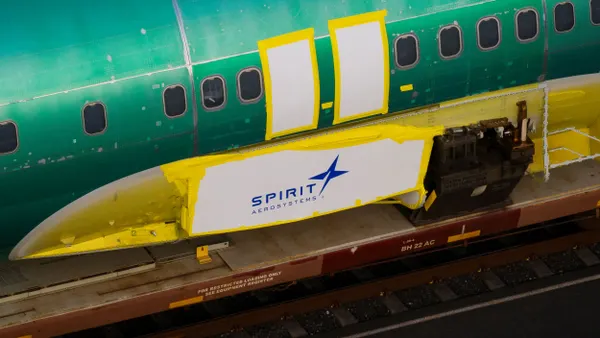 The left side of a shiny green plane fuselage with the blue and white Spirit AeroSystems logo.