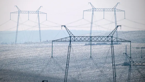 Electric power lines running across a hilly landscape.