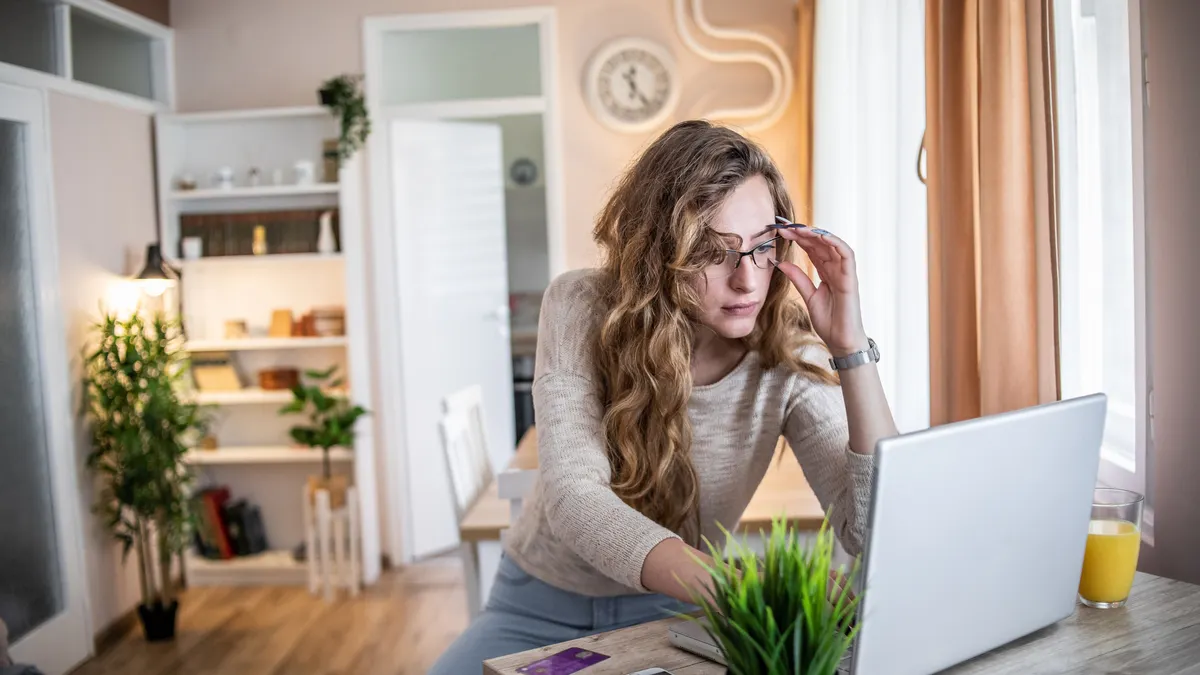 A woman shops on her computer in her home.