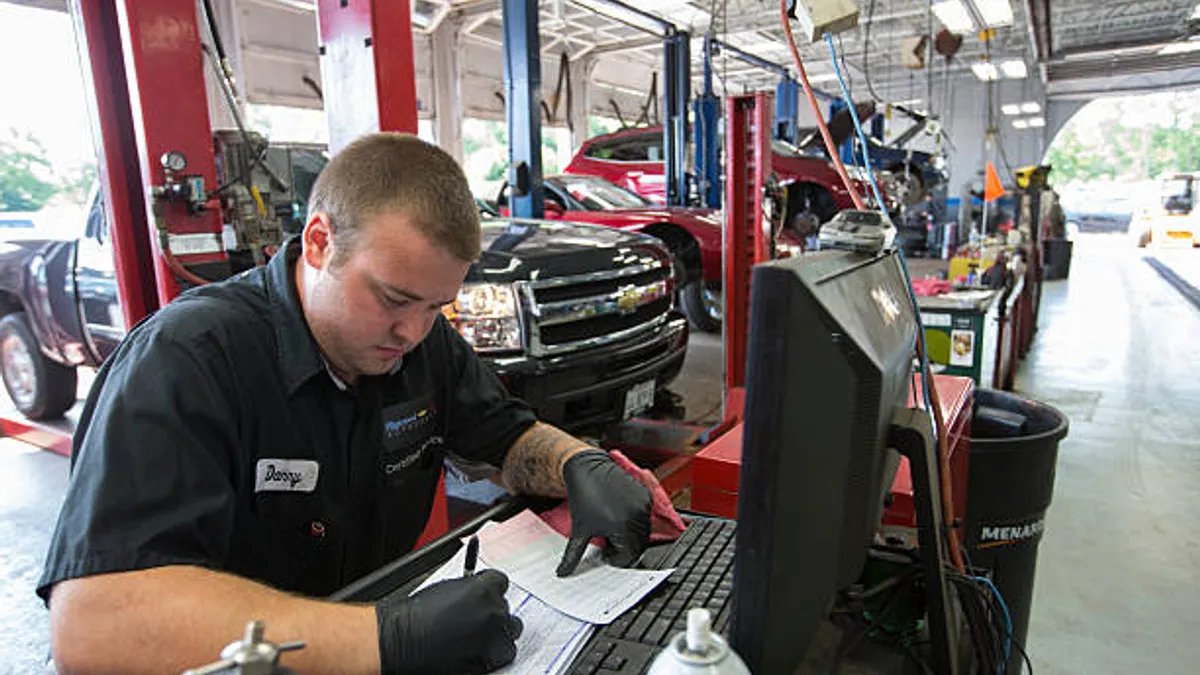 Technician working on vehicle.