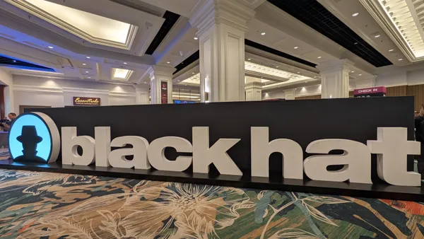 A large sign reading "Black Hat" sits in the carpeted foyer of a convention center