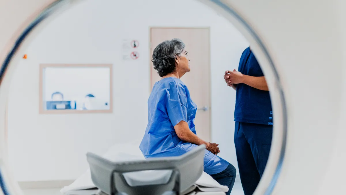 A picture of a woman talking to a nurse on an MRI tomography machine at a hospital.