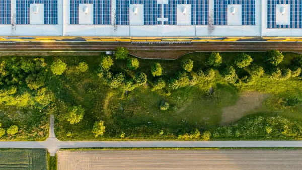 Arial view of of greenspace and a building with solar panels