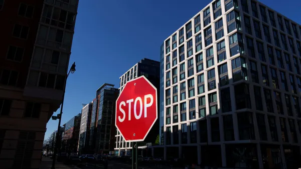 Tall apartment buildings in washington, dc with a stop sign in the foregound.