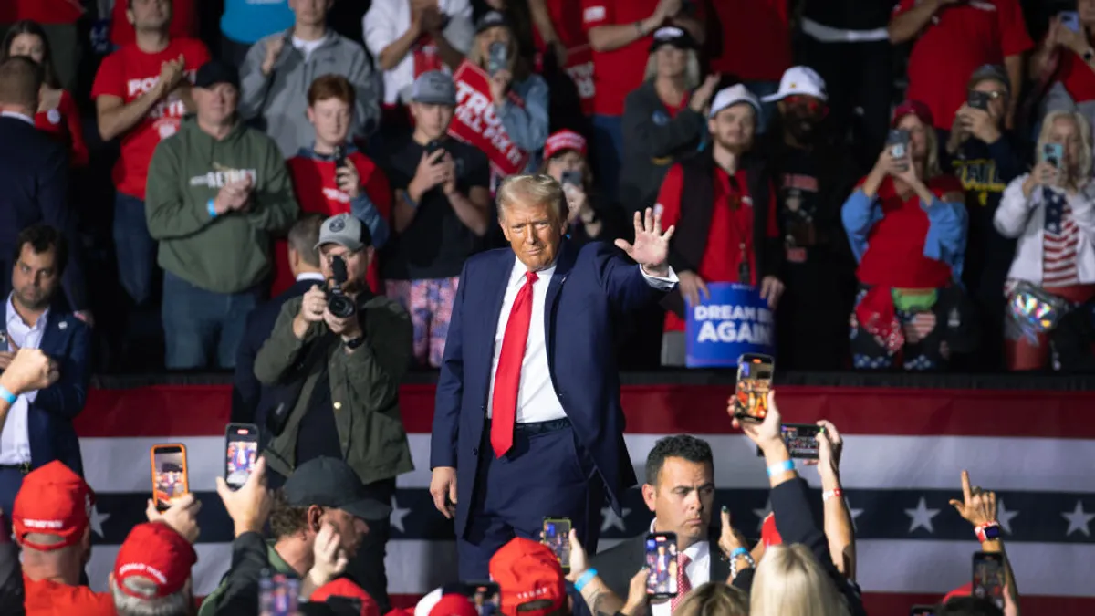 Former President Donald Trump waves to guests, who were standing and clapping, as he left a campaign rally in Grand Rapids, Michigan.