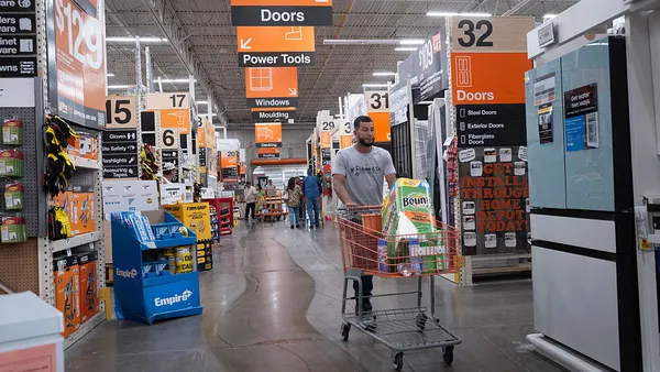 A customer pushes a cart through a Home Depot's aisles.