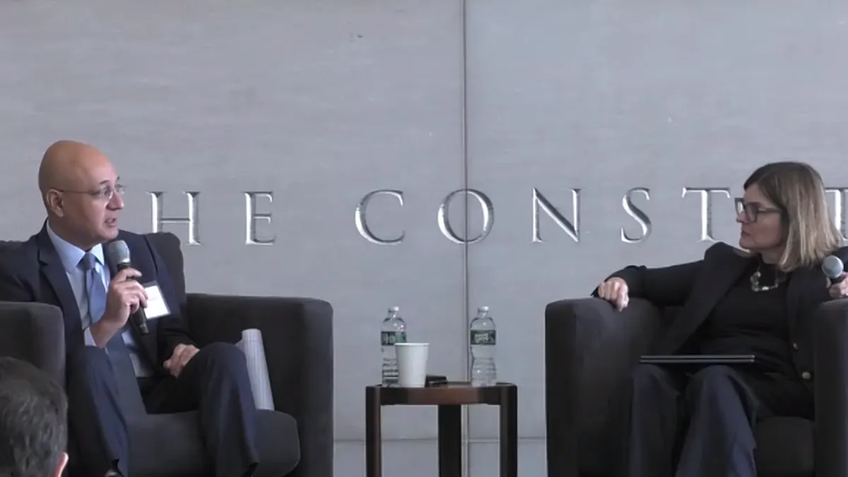 Two people sit in chairs talking to each other.