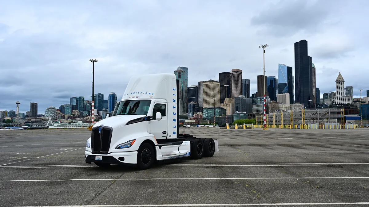 An electric truck parked sideways in a parking lot.
