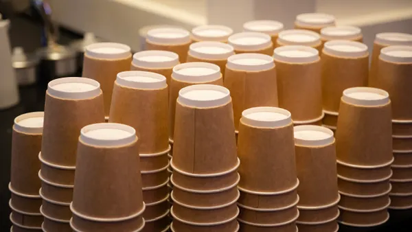 Stacks of upside down paper cups with integrated brown holders.