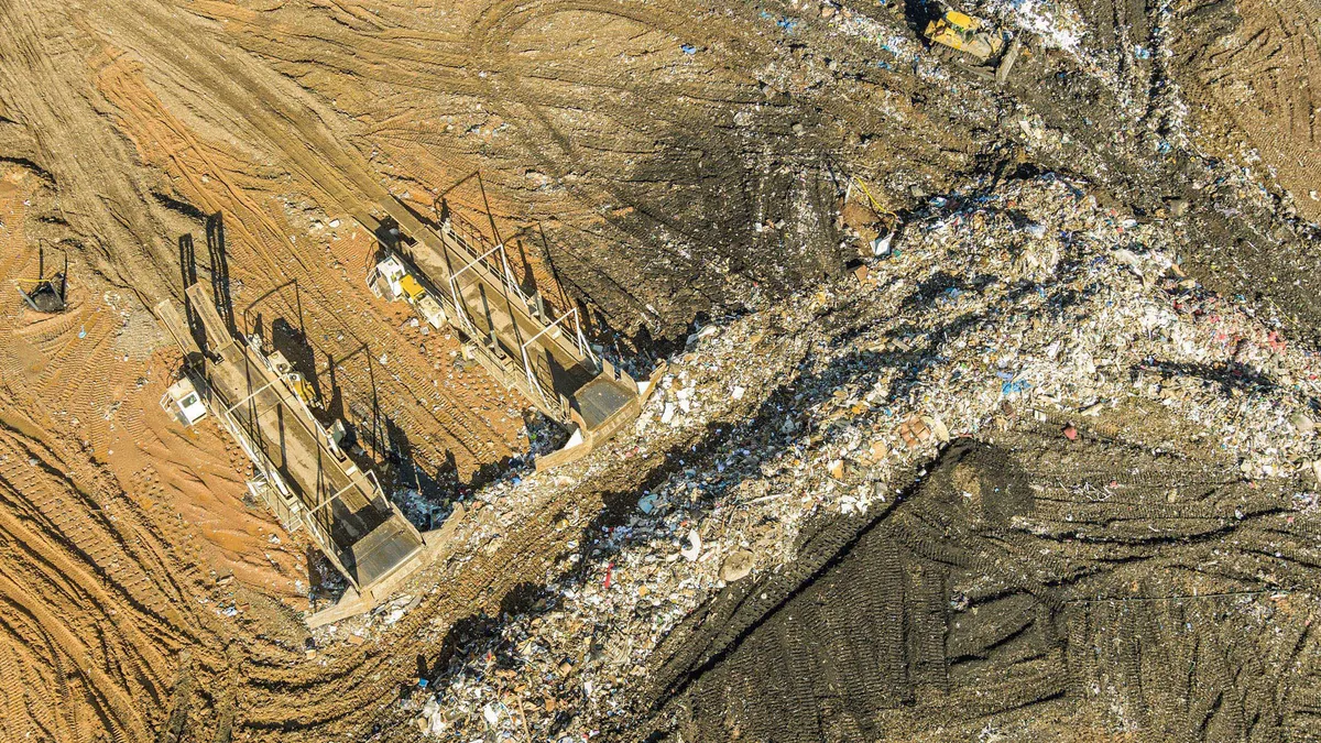 Aerial view of a municipal waste landfill in Pennsylvania shows two large bulldozers organizing the garbage into separate rows.