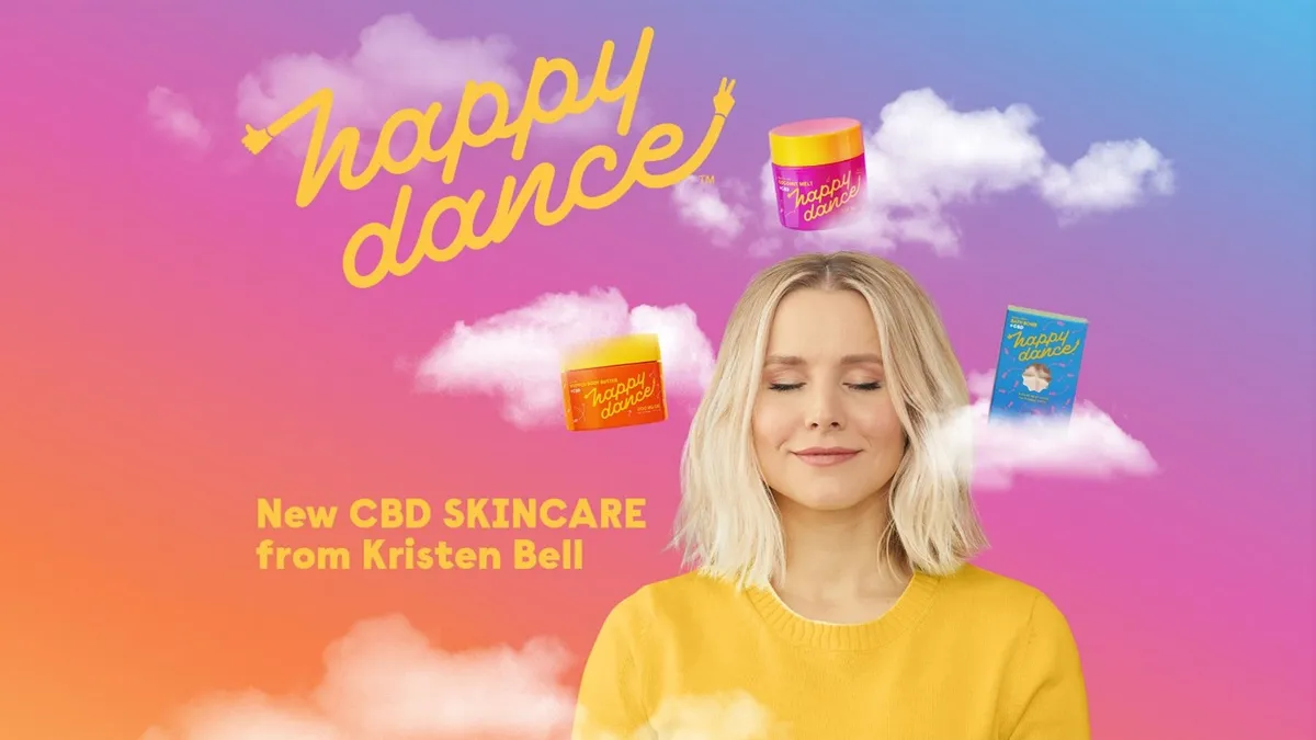 Person with short blonde hair surrounded by pink and purple clouds with the words Happy Dance in yellow