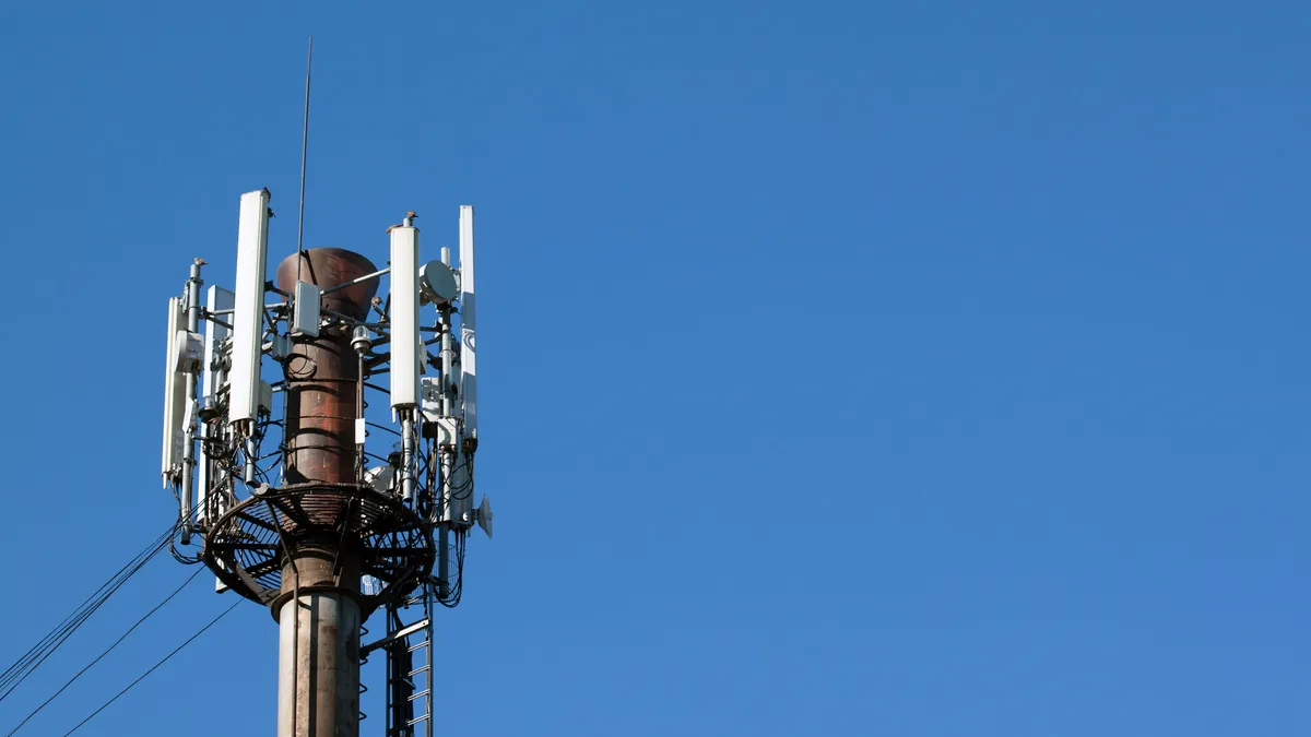 An electronic tower stands against a blue sky.