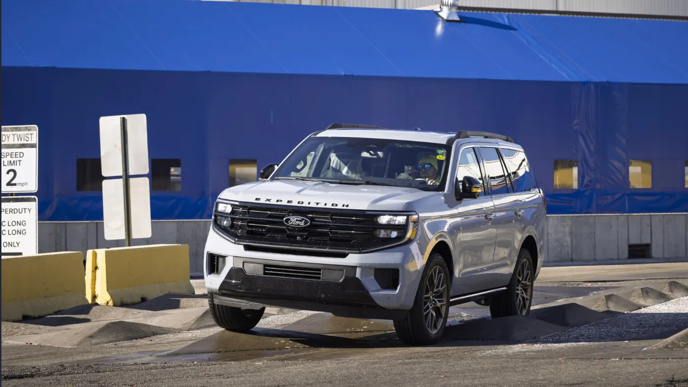 A Ford Expedition is being driven in front of the Ford Kentucky Truck Plant.